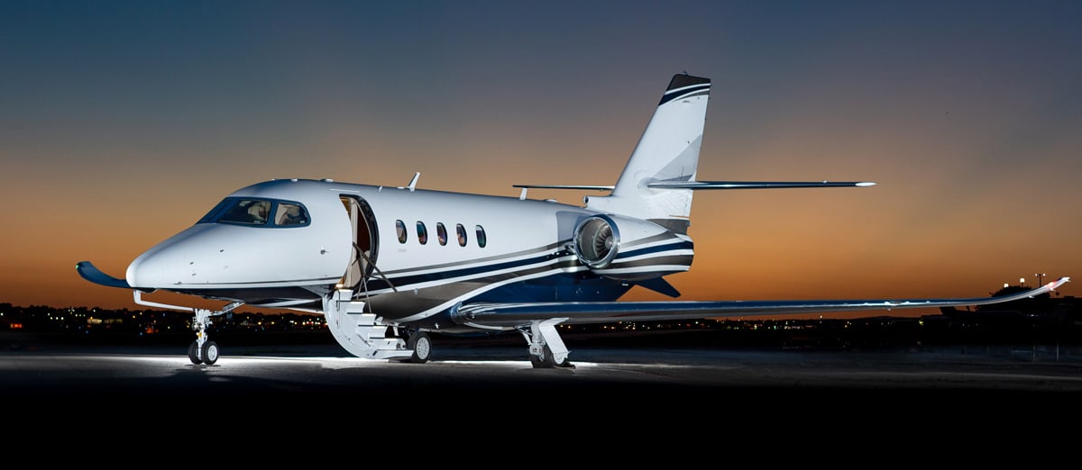 FlyPrivy Jet flying above sunset clouds